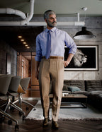 Full-body render of a silver-haired bearded Genesis 9 Male character in a lavender dress shirt, matching tie, khaki pleated trousers, and brown oxford shoes, standing confidently in an industrial loft interior.